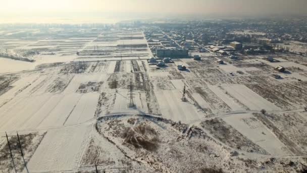 寒い冬に農村郊外の町エリアで雪に覆われた屋根を持つ民家の空中ビュー — ストック動画