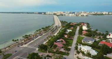 Florida 'daki Sarasota şehrinin havadan görünüşü, önünde yeşil palmiye ağaçları arasında ufukta ve rıhtımda yüksek binalar var. Birinci sınıf konut geliştirme.