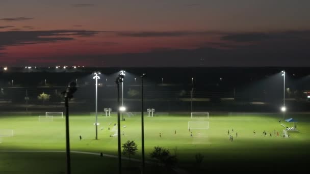 フロリダ州ノースポートの公共スポーツアリーナで照明が点灯し 夜間にサッカー場でサッカーをする人々がいた ブラックアウトコンセプト — ストック動画