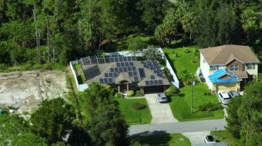 Banliyö bölgesinde temiz ekolojik elektrik enerjisi üretmek için çatısı güneş fotovoltaik panellerle kaplı Amerika 'daki sıradan bir ev. Özerk konut kavramı.