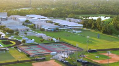 Florida, North Port 'taki devlet okulu spor salonunda okul çocukları çimen stadyumunda Amerikan futbolu oynuyor. Açık hava aktiviteleri konsepti.