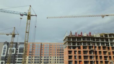 Yüksek konutlu apartman şantiyesindeki vinçler. Gayrimenkul geliştirme.