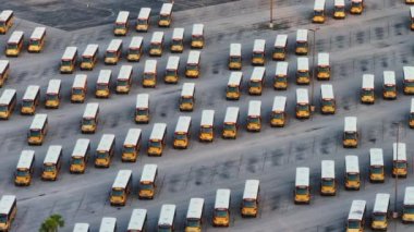 ABD 'de ilçe otoparkına park etmiş birçok okul otobüsünün hava görüntüsü. Amerikan eğitim sistemi ulaşımı.