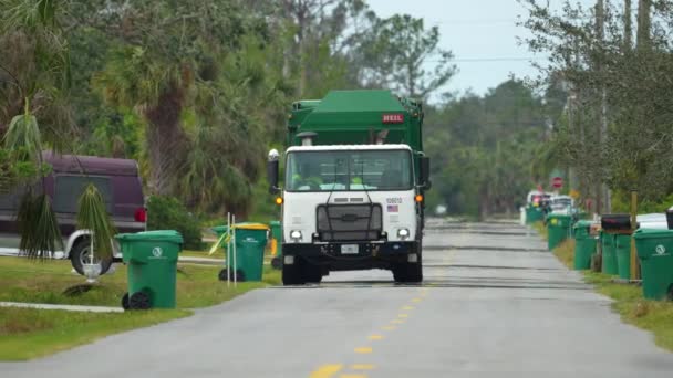アメリカのゴミトラックが田舎の通り側のゴミ箱を拾う — ストック動画