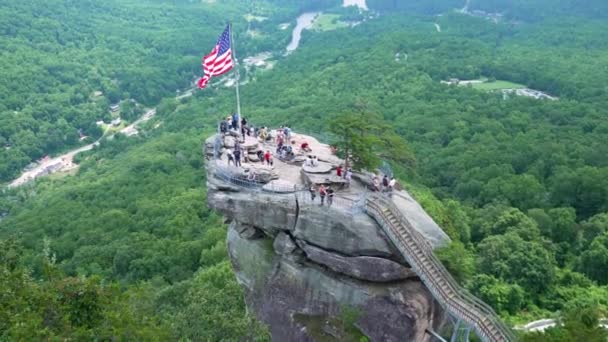 在美国北卡罗莱纳州的Chimney Rock州立公园 Chimney Rock带着奉承的美国国旗和许多游客 阿巴拉契亚山脉旅游胜地 — 图库视频影像