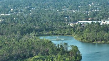 Florida orman ormanlarında şiddetli yangın söndürmek için gölden su dolduran acil servis helikopteri. Polis helikopteri ormanda yangın çıkarmaya çalışıyor..