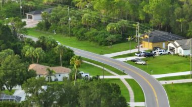 Florida 'daki küçük Amerikan kasabasında kırsal yol trafiği. Yeşil ağaçlar ve sakin yerleşim alanlarındaki banliyö sokakları arasında özel evler var..