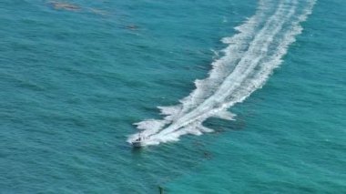 Dalgalanan su yüzeyi ile okyanus dalgaları üzerinde hızla giden küçük bir tekne. Yelkenli Florida 'da okyanusta hareket ediyor..
