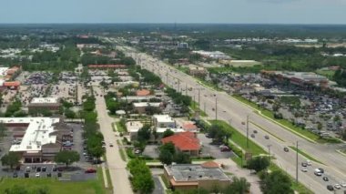 North Port, Florida 'daki American Geniş Yolu ve alışveriş merkezi plazasından görüntü. Sürücü arabalı şehir trafiği. ABD ulaştırma altyapı kavramı