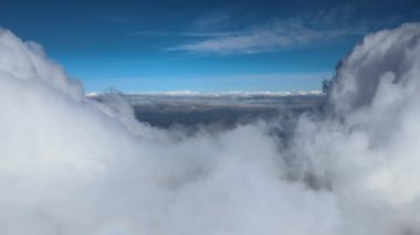 Dünya 'nın yüksek irtifasında, yağmur fırtınasından önce oluşan kabarık kümülüs bulutlarıyla kaplı uçak penceresinden hava görüntüsü.