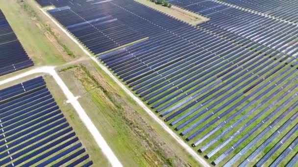 きれいな電気エネルギーを生成するための太陽光発電パネルの多くの行を持つ大規模な持続可能な電気発電所の空中ビュー 排出ゼロをコンセプトとした再生可能エネルギー — ストック動画