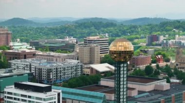 ABD 'nin Tennessee kentindeki Knoxville şehrinin şehir merkezindeki hava manzarası. Dünya Fuar Parkı 'ndaki güneş küresi ve modern Amerikan şehir merkezindeki yüksek gökdelen binaları.