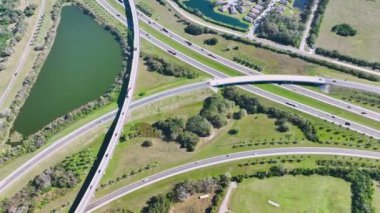Aerial view of freeway overpass junction with fast moving traffic cars and trucks in american rural area. Interstate transportation infrastructure in USA.