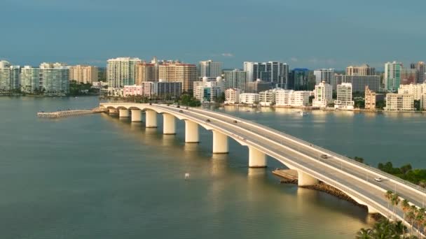 リングリングブリッジと水平線上の高層オフィスビルとサラソータ市内中心部の空中ビュー フロリダ州の不動産開発 アメリカ旅行先 — ストック動画