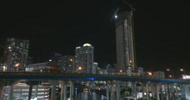 ABD ulaşım altyapısı konsepti. Miami City, Florida 'daki geniş otoyol kavşağının üzerinde gece hızlı giden arabalarla