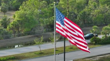 Amerikan ulusal bayrağı rüzgarda dalgalanıyor. Demokrasinin sembolü olarak gösterilen Amerikan yıldızlarının ve çizgilerinin havadan görünüşü.