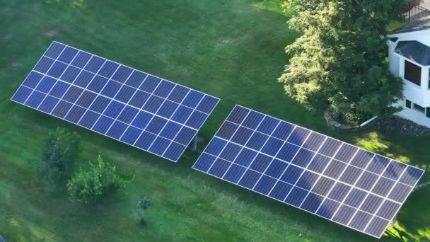 郊外の農村部できれいな生態系の電気エネルギーを発生させるために裏庭の地面に独立したフレーム上に太陽光発電パネルを搭載した民家 自律住宅の概念 — ストック動画