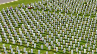 Sarasota Ulusal Mezarlığı 'nda yeşil çimlerin üzerinde bir sürü beyaz mezar taşı var. Anma Günü konsepti.