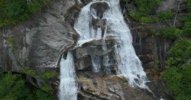 Yüksek şelalenin güzel manzarası, kayalık kayalardan yeşil gür ormanların arasına düşen berrak su. Nantahala Ulusal Ormanı 'ndaki Whitewater Şelalesi, Kuzey Carolina, ABD.