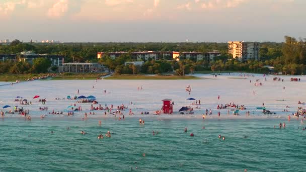 사라소타의 붐비는 Siesta Key 해변의 사람들이 물에서 일몰에 따뜻한 플로리다 — 비디오