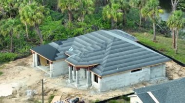 Çatısı asfalt kaplama tabakasıyla kaplı. Yeni eve kiremit döşenmeye hazır. Çatı inşaatı. Florida Emlak Geliştirme.