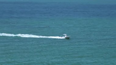 Dalgalanan su yüzeyi ile okyanus dalgaları üzerinde hızla giden küçük bir tekne. Yelkenli Florida 'da okyanusta hareket ediyor..