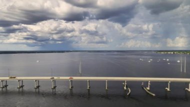 Aerial view of Barron Collier Bridge and Gilchrist Bridge in Florida with moving traffic. Transportation infrastructure in Charlotte County connecting Punta Gorda and Port Charlotte over Peace River.