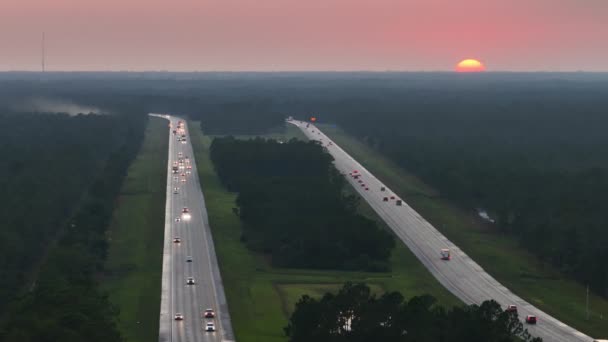日没の速い移動トラフィックを持つ忙しいアメリカの高速道路の空中ビュー 州間輸送の概念 — ストック動画