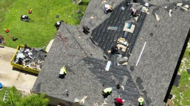 Çatıda asfalt kiremitler var. İnşaat işçileri evin çatısını kontrol ediyor. Florida 'daki evin tamiri. Gayrimenkul geliştirme kavramı.