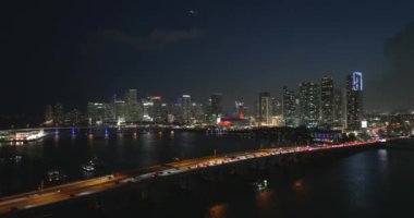Gece yarısı Miami, Florida 'daki geniş otoyol köprüsünde Amerikan şehrinde yoğun trafik vardı. Kentsel ulaşım altyapısının üstündeki gökdelen binaları. Miami, ABD - 5 Mayıs 2023.