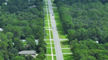Florida 'daki küçük Amerikan kasabasında kırsal yol trafiği. Yeşil ağaçlar ve sakin yerleşim alanlarındaki banliyö sokakları arasında özel evler var..