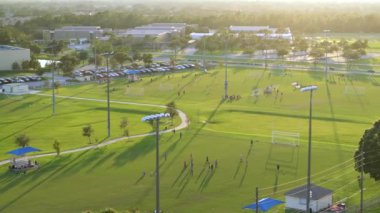 Okul çocukları gün batımında okul stadyumunda fiziksel egzersiz yaparken futbol oynuyorlar. Aktif yaşam konsepti.