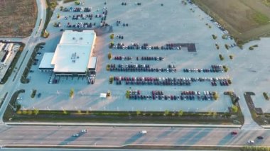Otoyol kenarında satılık bir sürü yeni araba olan açık hava otoparkının üzerinden bir görüntü. Amerikan otomotiv endüstrisinin gelişimi kavramı.
