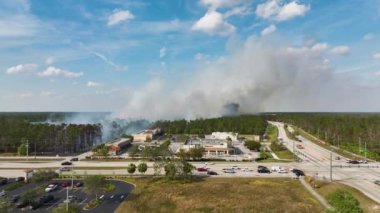 Kurak kış mevsiminde Florida 'nın North Port şehrinde şiddetli yangın çıktı. Banliyö evlerinden yükselen yoğun duman.