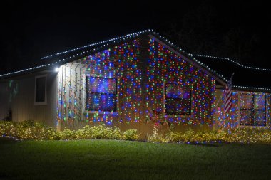 Florida aile evinin ön bahçesinde parlak ışıklandırılmış noel süslemeleri. Kış tatili için dışarıda dekor.