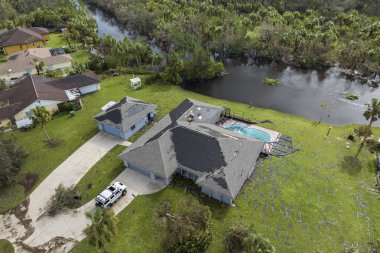 Kasırga tarafından yıkılan, çatısı hasarlı ve Florida yerleşim bölgesinde yüzme havuzu olan özel bir rüzgar evi. Doğal afet ve bunun sonuçları.