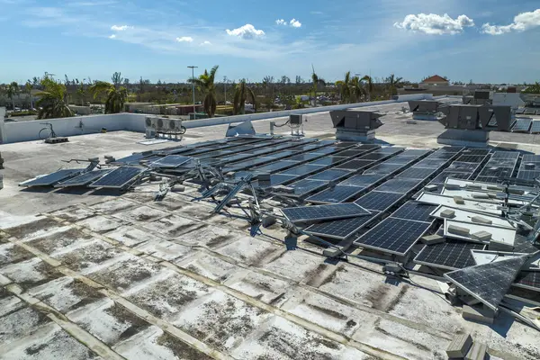 Fırtınalar tarafından yıkılan fotovoltaik güneş panelleri yeşil ekolojik elektrik üretmek için endüstriyel binaların çatısına monte edildi. Florida 'daki doğal afet sonuçları.