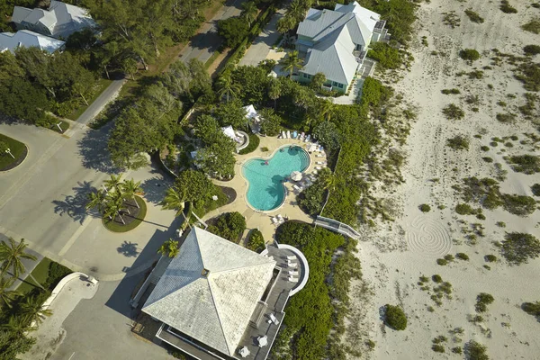 Expensive mansions between green palm trees on Gulf of Mexico shore in island small town Boca Grande on Gasparilla Island in southwest Florida, USA. Aerial view of wealthy waterfront neighborhood.