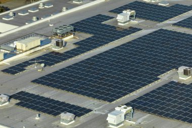Fotovoltaik güneş panelleri yeşil ekolojik elektrik üretmek için sanayi binasının çatısına monte edildi. Sürdürülebilir enerji konsepti üretimi.