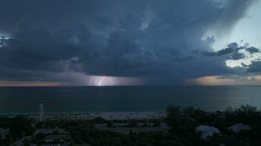 Karanlık evleri ve okyanus kıyısında uzun deniz feneri olan bir sahil kasabası fırtınalı bir gecede gemilerin seyrüsefer için yanıp sönen bir ışık. Deniz üzerinde şimşekler çakan fırtına gemiler için tehlike arz ediyor..