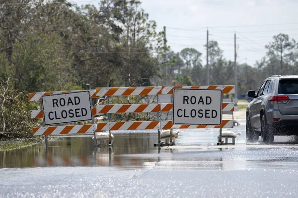 Florida 'da kasırga sonrası caddeyi su basmış. Kapalı levhalar araba sürmeyi engelliyor. Doğal afet konsepti sırasında ulaşımın güvenliği.