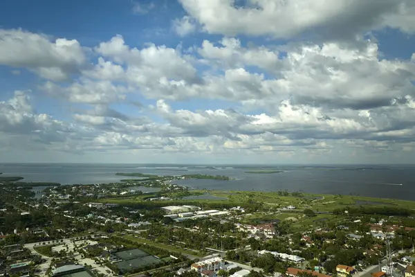 Aerial view of wealthy waterfront neighborhood. Expensive mansions between green palm trees on Gulf of Mexico shore in island small town Boca Grande on Gasparilla Island in southwest Florida, USA.