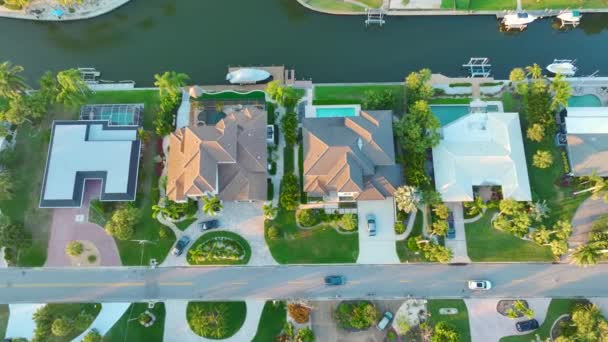 フロリダ州サラソータ市の裕福な地区の上から見ると 緑のヤシの木の間に高価なウォーターフロントハウスがあります アメリカのプレミアムハウスの開発 — ストック動画
