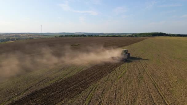夏に種を蒔くための土壌を準備する農場を耕作するトラクターの空中視野 — ストック動画