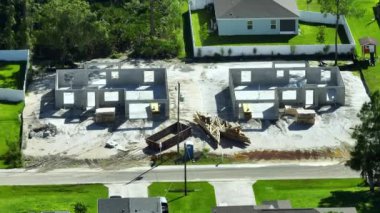 İnşaat halinde yeni bir evi olan bir inşaat alanı. Ahşap çatı kirişleri döşenmeye hazır tuğladan duvarları olan tamamlanmamış bir ev iskeleti..