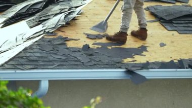 Çatıdan eski asfalt kiremitlerin çıkarılması. İnşaat işçileri çatı kaplamasını değiştiriyor. Florida 'daki evin tamiri. Gayrimenkul geliştirme kavramı