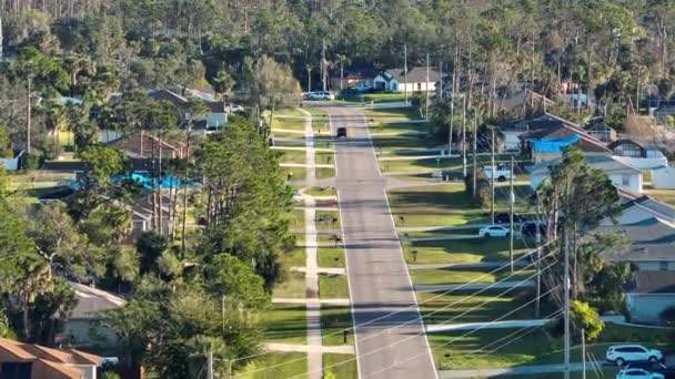 フロリダの小さな町で車を運転する農村の道路交通 静かな住宅地のプライベートハウスを持つアメリカの郊外風景 — ストック動画
