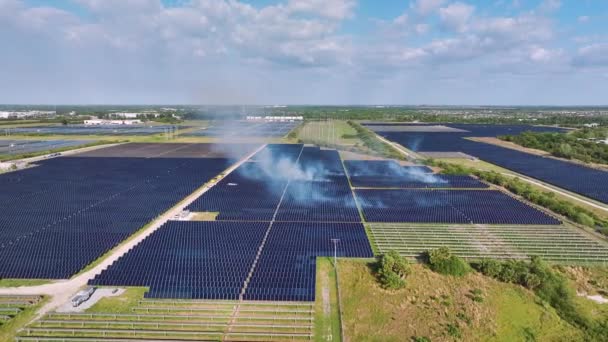 从上面的野火之间的光伏发电厂与多排太阳能电池板生产清洁电能的观点 关键设施的自然灾害概念 — 图库视频影像