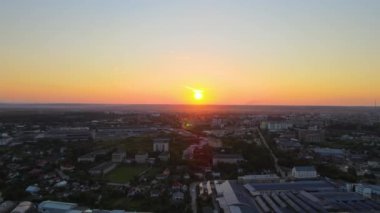 Aerial view of goods warehouses and logistics center in industrial city zone at sunset.