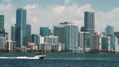 Miami Brickell, Florida, ABD. Şehir merkezindeki beton ve cam gökdelen binaların önünde lüks bir yat kullanıyor. Güneşli bir günde iş dünyasının finans bölgesiyle Amerikan megapolis 'i